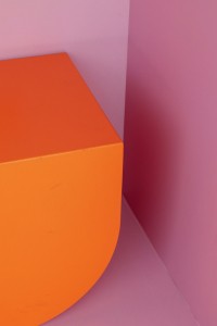 Fauteuil orange design, sur un mur et fond rose, couleurs vives