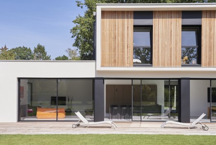 Façade d'une maison moderne blanche bardage en bois brut et contour fenêtres gris anthracite en peinture Tollens