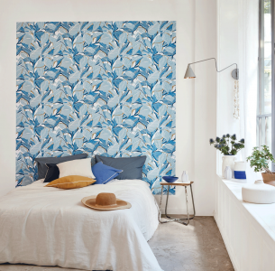 Papier peint à motif jungle couleur bleu grec en tête de lit dans une chambre pour adulte, marque Casadeco modèle Méditerranée Riviera